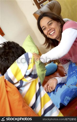 mother and son having fun during a pillow fight
