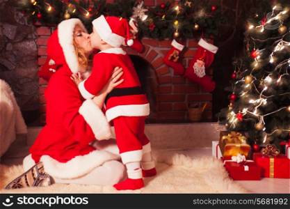Mother and son in Christmas room with decorated tree and fireplace