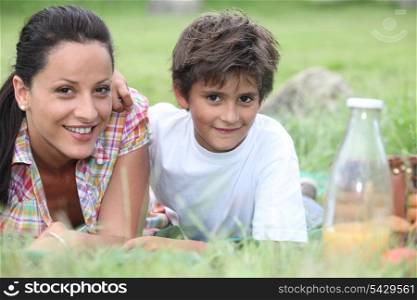 Mother and son lying in the grass