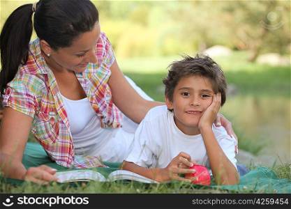 Mother and son lying on the grass
