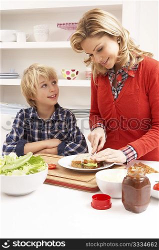 Mother And Son Making Sandwich In Kitchen