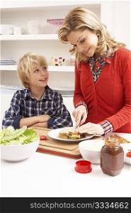 Mother And Son Making Sandwich In Kitchen