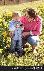 Mother And Son On Easter Egg Hunt In Daffodil Field