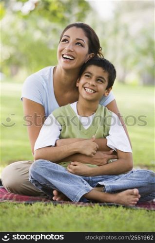 Mother and son outdoors in park bonding and smiling (selective focus)