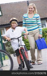 Mother and son outside school with bicycle