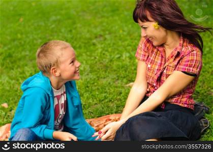 Mother and son play outside on field in the park
