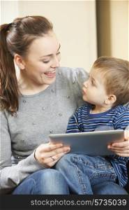 Mother And Son Playing On Digital Tablet Together