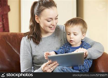 Mother And Son Playing On Digital Tablet Together