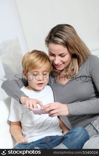 Mother and son playing video game on telephone