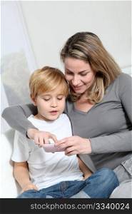 Mother and son playing video game on telephone