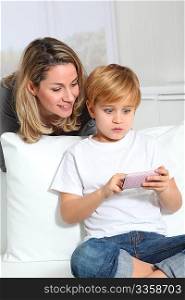 Mother and son playing video game on telephone