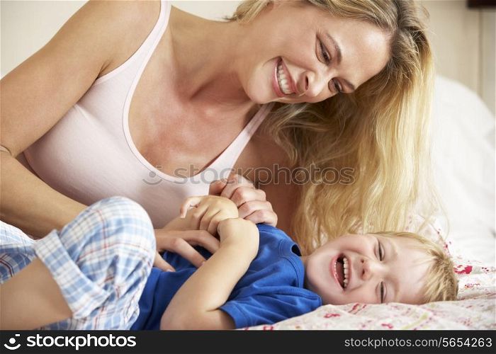Mother And Son Relaxing Together In Bed