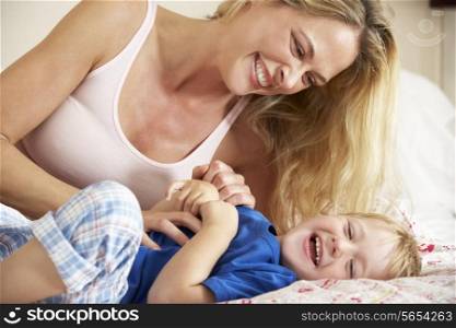 Mother And Son Relaxing Together In Bed