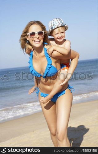 Mother And Son Running Along Beach
