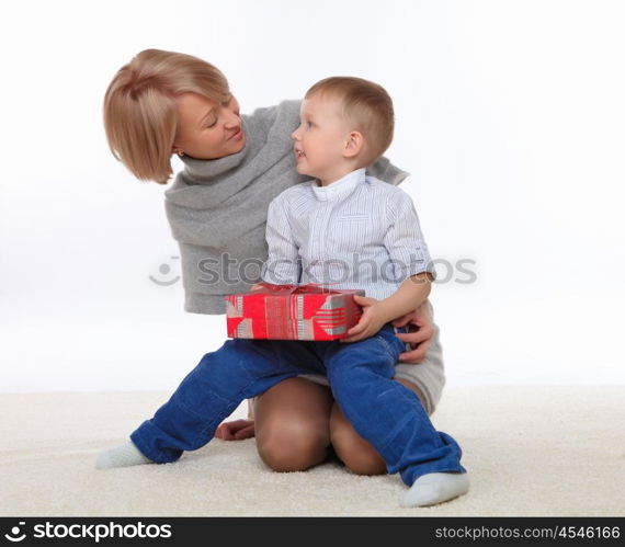 mother and son sitting on the floor and holding a present box