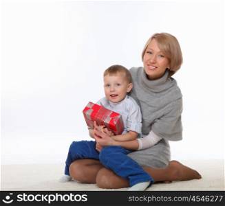 mother and son sitting on the floor and holding a present box