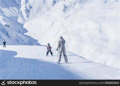 Mother and son skiing enjoying winter season on top of ski resort.  . Mother and Son Skiing Together