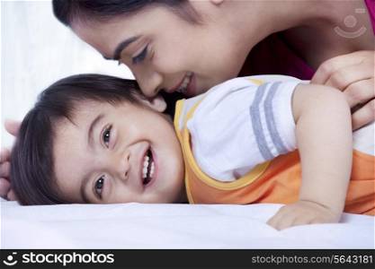Mother and son smiling on a bed