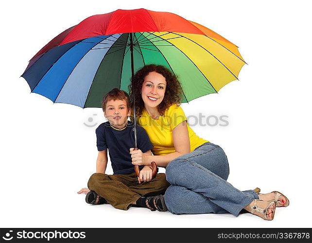 mother and son with big multicolored umbrella sitting isolated on white and looking at camera