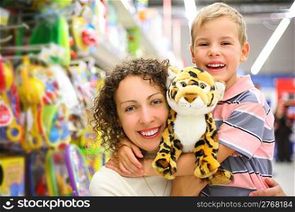 Mother and son with soft toy in shop