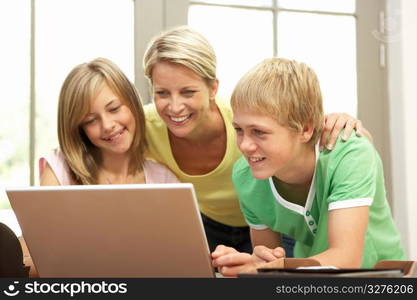 Mother And Teenage Children Using Laptop At Home