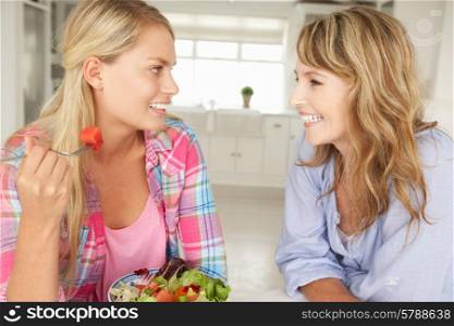 Mother and teenage daughter enjoying food at home
