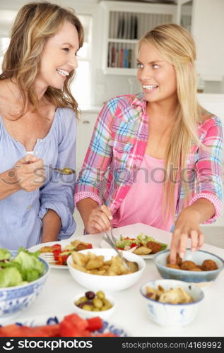 Mother and teenage daughter enjoying meal at home