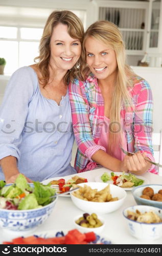 Mother and teenage daughter enjoying meal at home