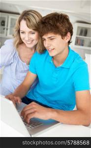 Mother and teenage son using laptop