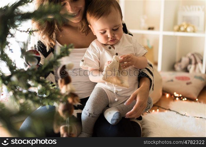 Mother and toddler decorating the Christmas tree.