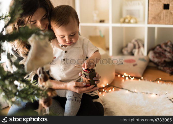 Mother and toddler decorating the Christmas tree.