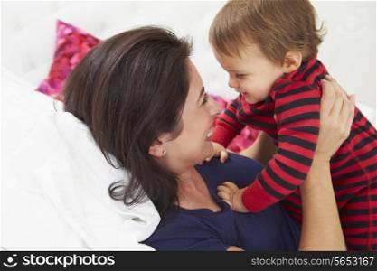 Mother And Toddler Lying In Bed Together