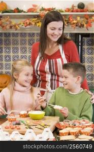 Mother and two children at Halloween making treats and smiling