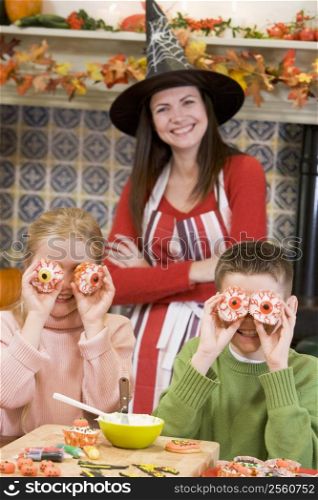 Mother and two children at Halloween playing with treats and smiling