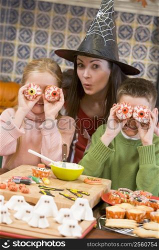 Mother and two children at Halloween playing with treats and smiling