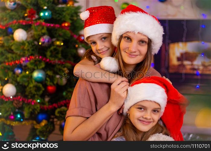 Mother and two daughters at the Christmas tree