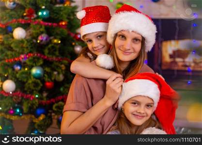 Mother and two daughters at the Christmas tree