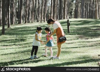 Mother and two daughters do some activities together at a camp in the woods. Family camping, spending time together on vacation.