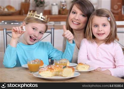 Mother and two daughters eating cake