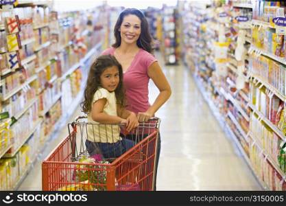 Mother and young daughter shopping at a grocery store.