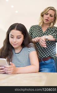 Mother Arguing With Teenage Daughter Over Use Of Mobile Phone