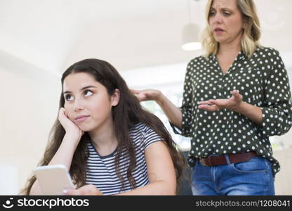 Mother Arguing With Teenage Daughter Over Use Of Mobile Phone