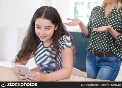 Mother Arguing With Teenage Daughter Over Use Of Mobile Phone