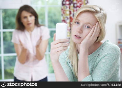 Mother Arguing With Teenage Daughter Over Use Of Mobile Phone