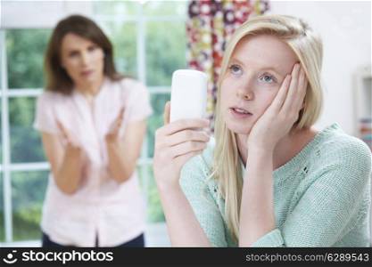 Mother Arguing With Teenage Daughter Over Use Of Mobile Phone