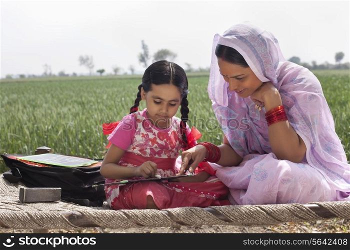 Mother assisting daughter with her homework