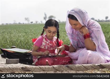 Mother assisting daughter with her homework