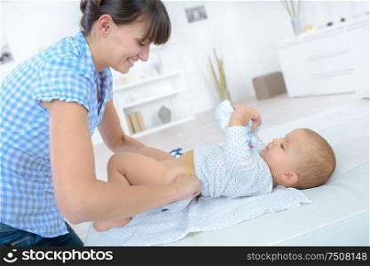mother at home changing babys nappy