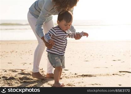 Mother at the beach with her baby. Young mother exploring the beach with her baby