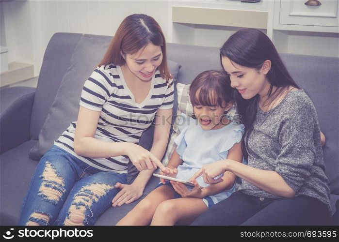Mother, Aunt and kid having time together lerning with using tablet at home with relax and happy on couch, education and lifestyle concept.